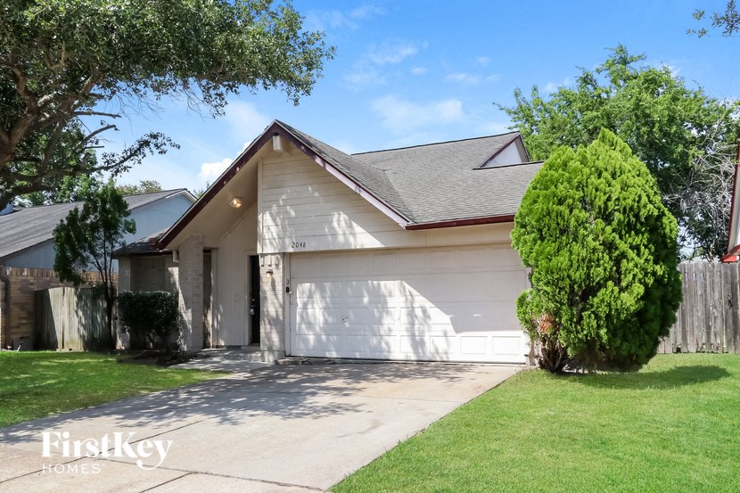 a white house with a white garage door and a lawn