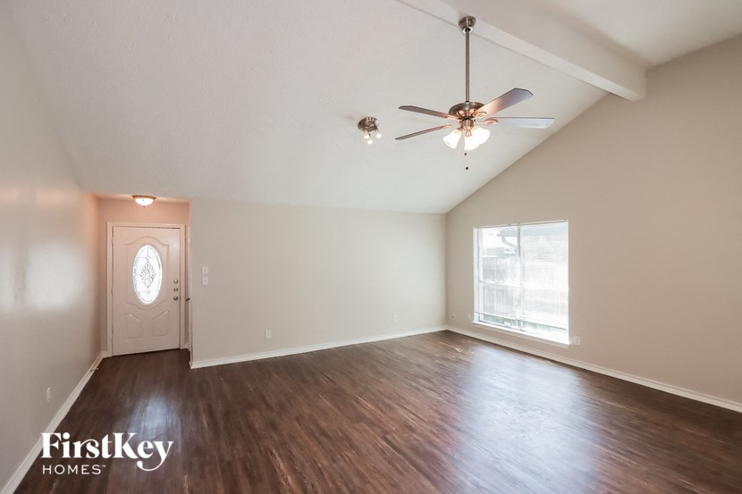 the living room with hardwood flooring and a ceiling fan