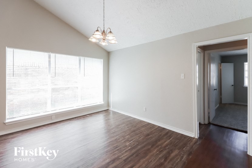 an empty living room with wood floors and a large window