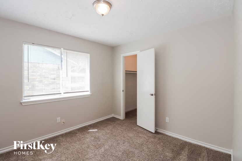 a bedroom with a large window and a door to a closet