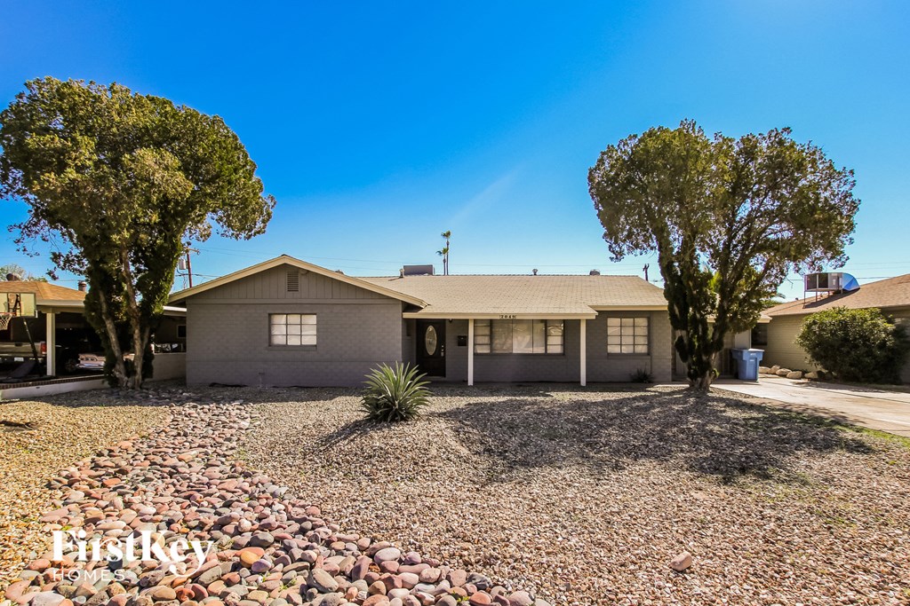 a house with rocks and trees in front of it