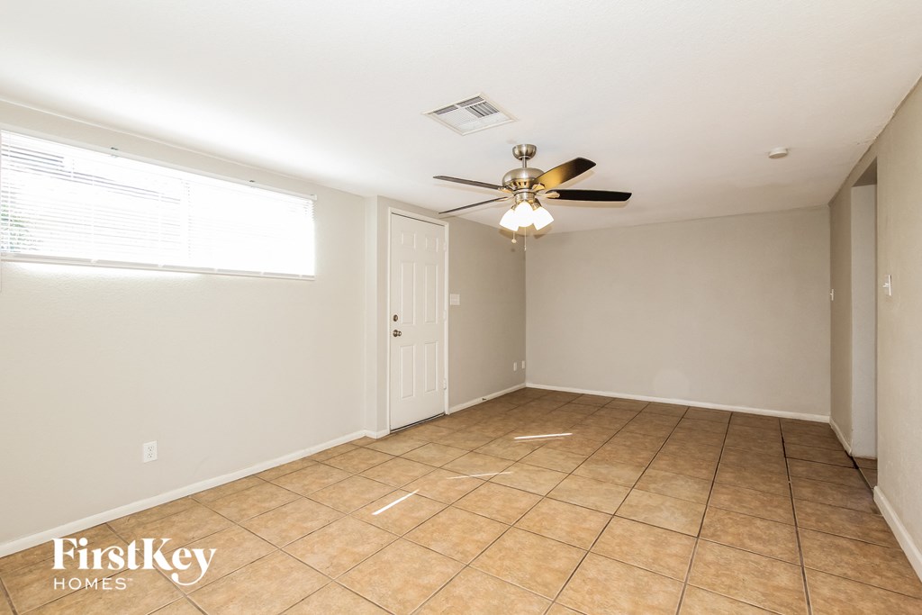 a empty room with a ceiling fan and a tiled floor