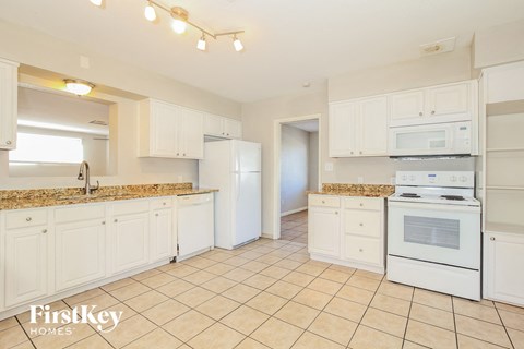 a white kitchen with white appliances and white cabinets