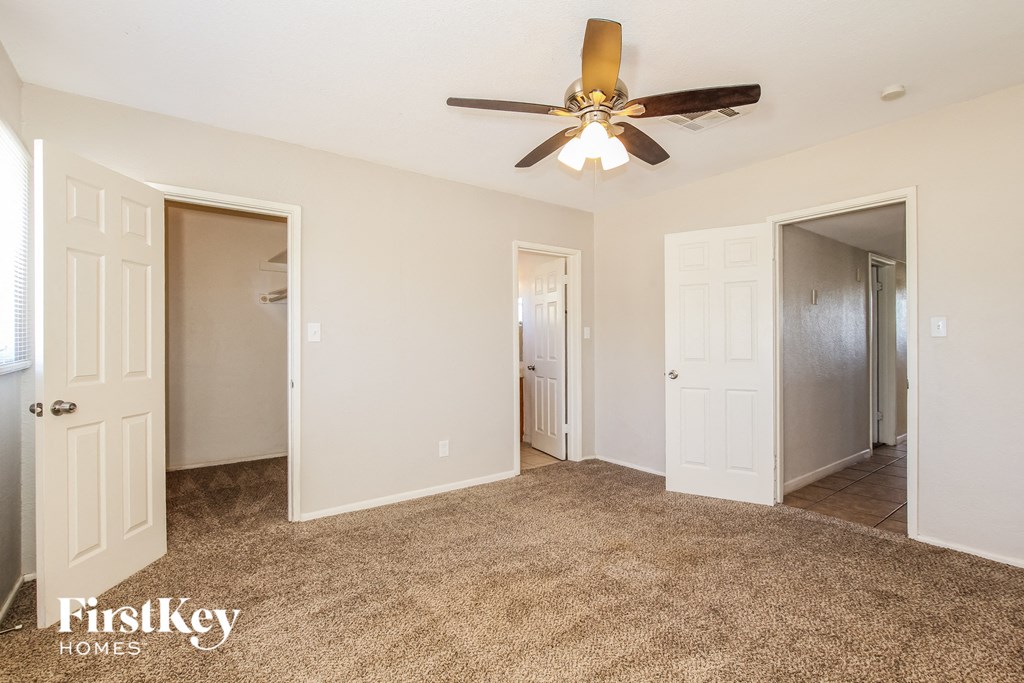 a bedroom with a ceiling fan and a door to a closet