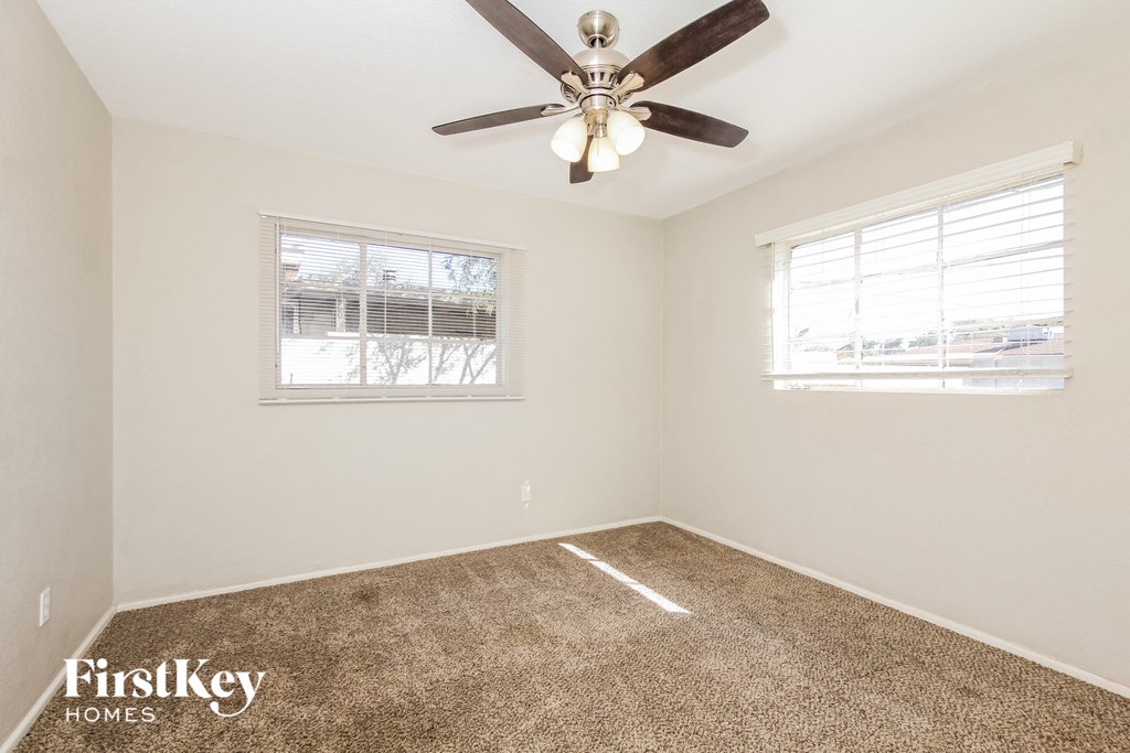 a bedroom with a ceiling fan and a window