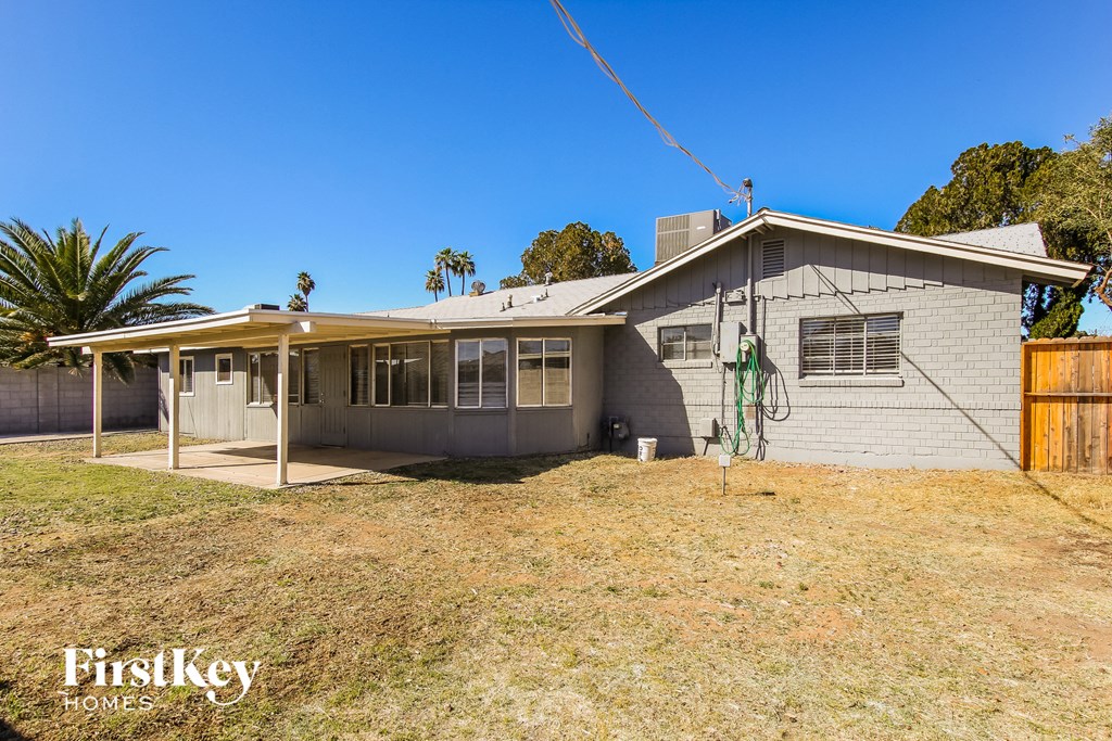 a small white house with a yard and a fence