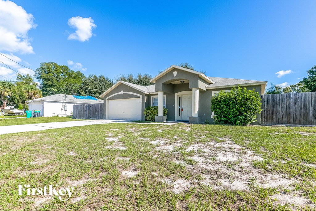 a home with a yard and a fence and a house
