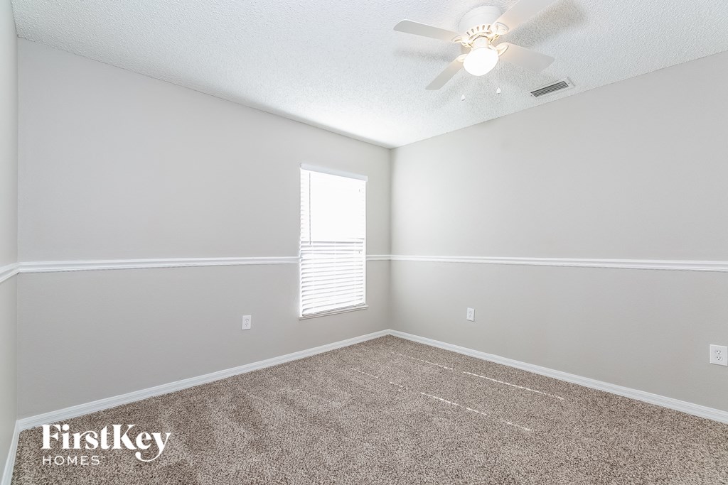 a bedroom with a ceiling fan and a window