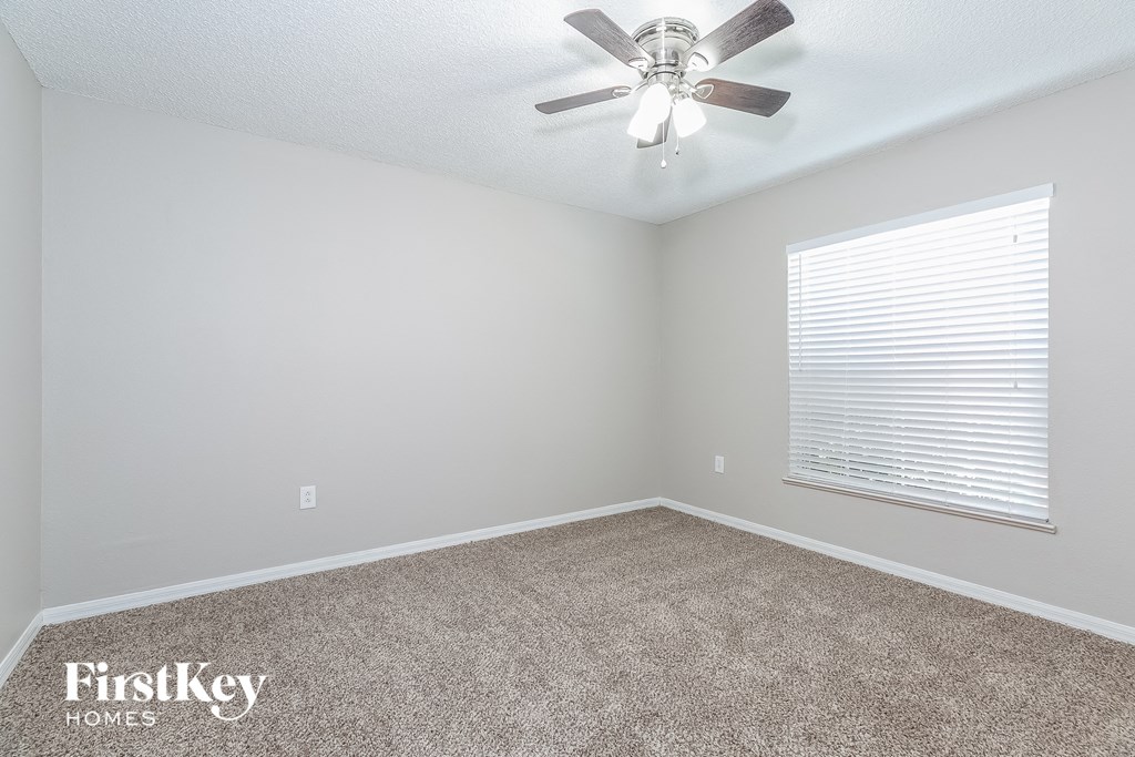 a bedroom with a ceiling fan and a window