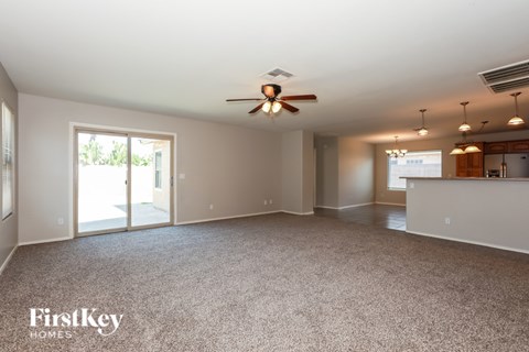 A spacious room with a ceiling fan and a carpeted floor.