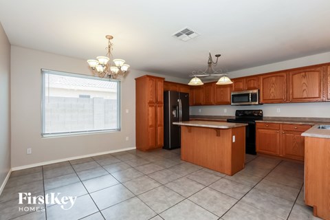 A kitchen with wooden cabinets and a black refrigerator.