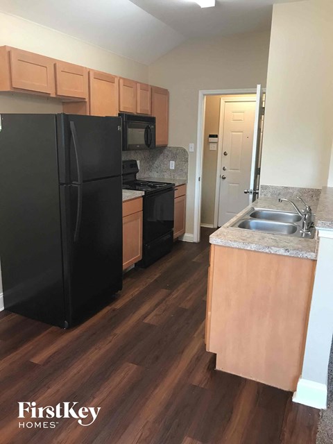 a kitchen with a black refrigerator and a sink