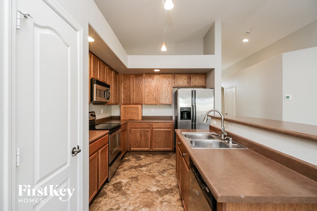 a kitchen with wooden cabinets and stainless steel appliances