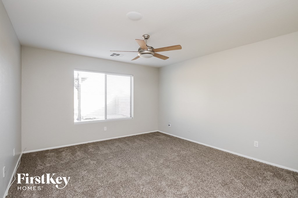 a bedroom with carpet and a ceiling fan