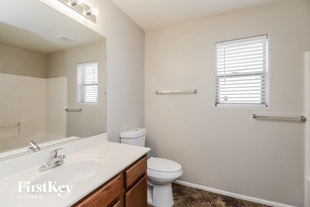 a bathroom with a sink toilet and a mirror