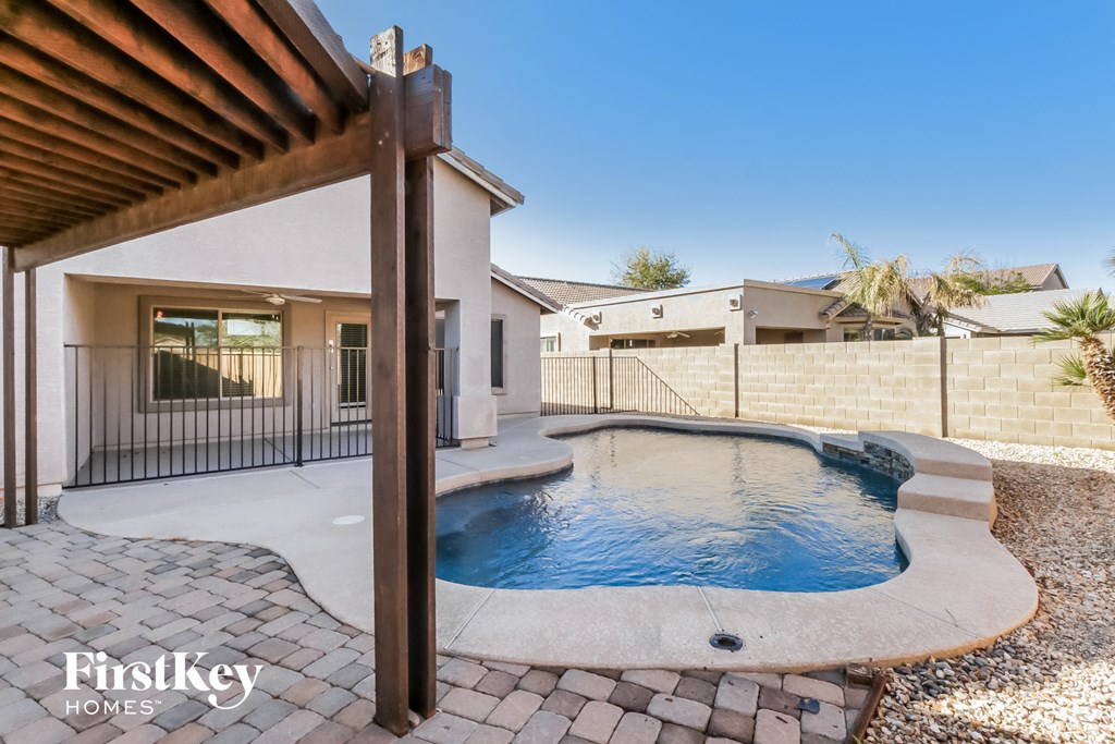 a small pool in a backyard with a house