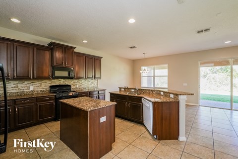 a kitchen with granite counter tops and wooden cabinets
