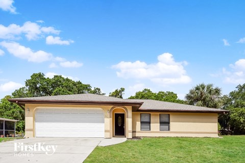 A two-car garage with a beige house in the background.