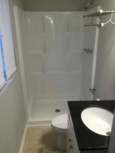 a white bathroom with a shower and a sink