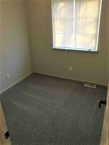 an empty room with a door and a window