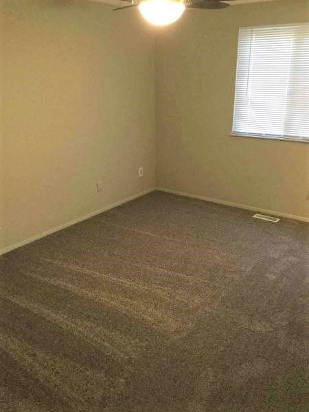 an empty room with a carpeted floor and a window