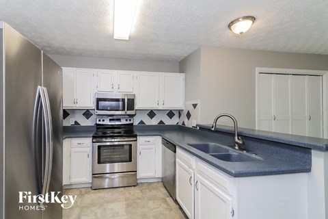 a kitchen with white cabinets and stainless steel appliances