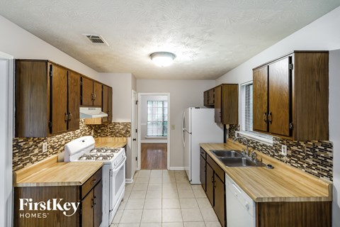 A kitchen with wooden cabinets and a white refrigerator.