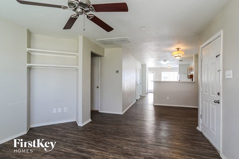 a renovated living room and kitchen with a ceiling fan