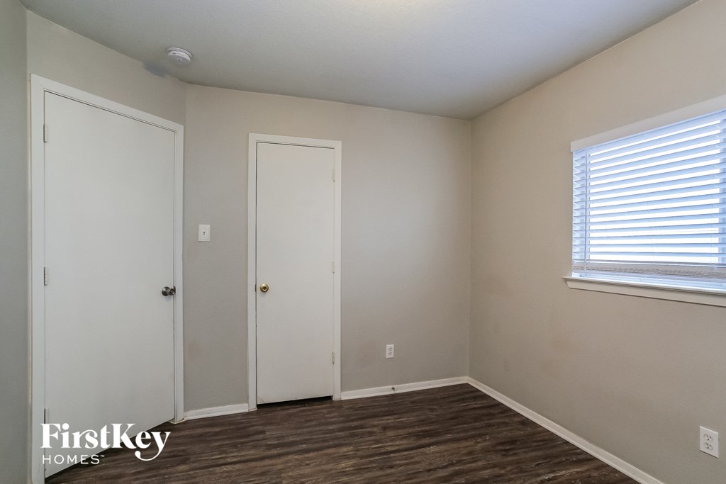 a bedroom with white walls and a window and a door