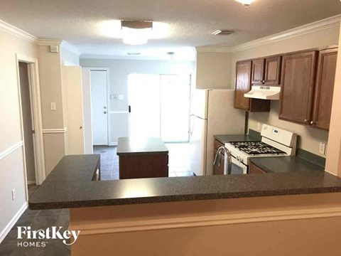 A kitchen with a black counter top and wooden cabinets.