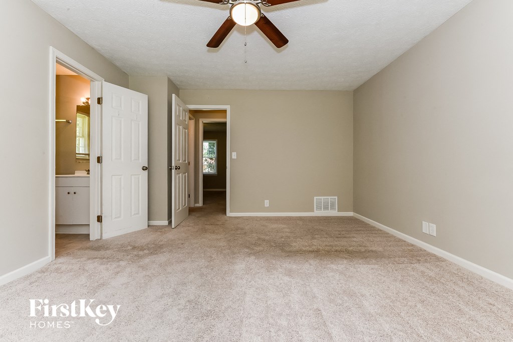 an empty living room with carpet and a ceiling fan