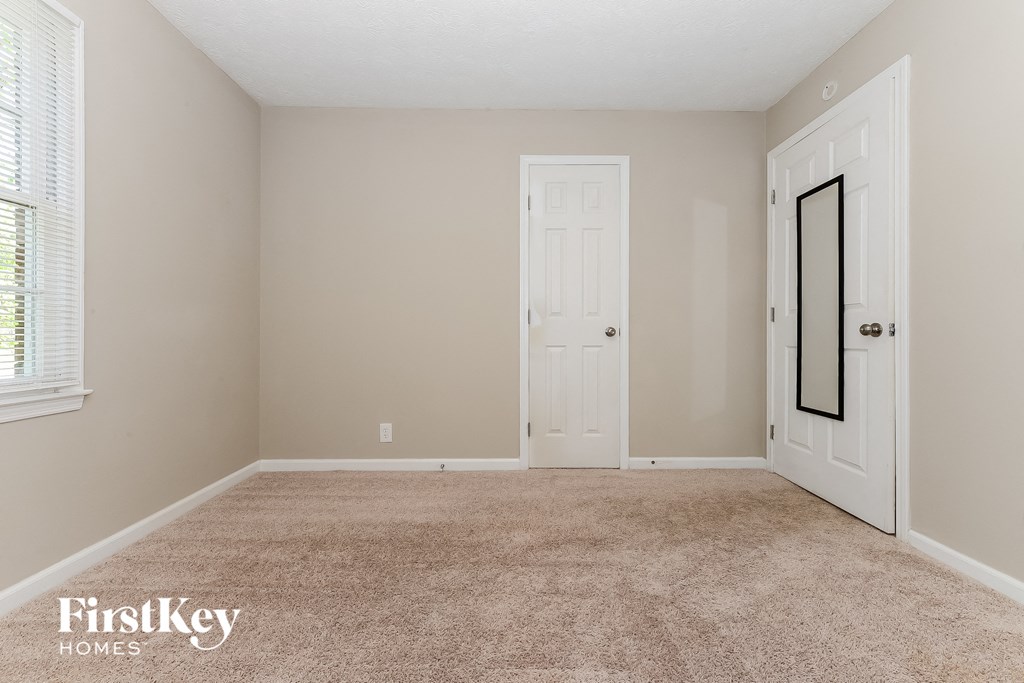a bedroom with a carpeted floor and a white door