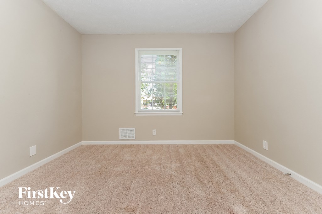 a bedroom with a carpeted floor and a window