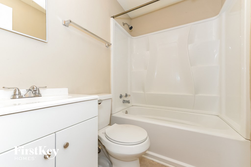 a bathroom with a toilet and a tub and a sink
