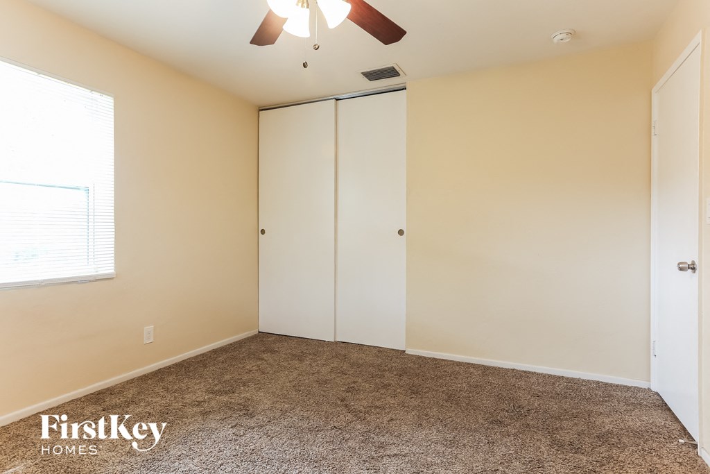 a bedroom with a closet and a ceiling fan