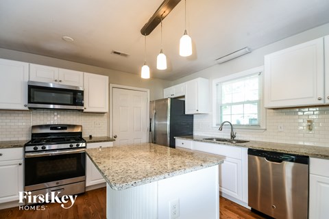 A kitchen with a granite countertop and stainless steel appliances.