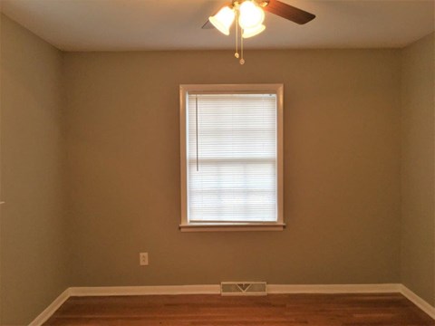 a living room with a window and a ceiling fan