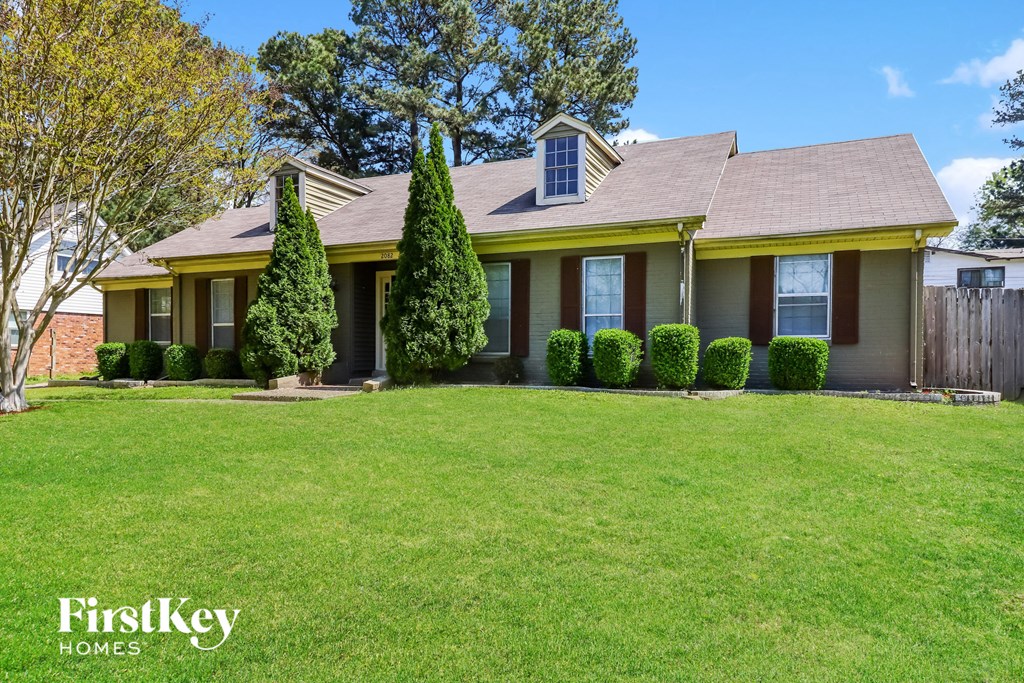 a yellow house with a lawn in front of it