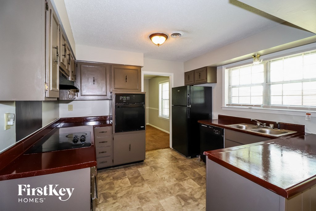 a kitchen with black appliances and brown counter tops