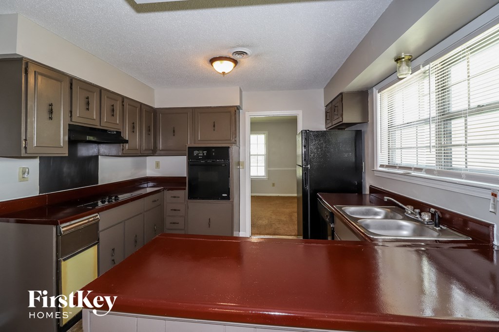 a kitchen with a red counter top and a sink