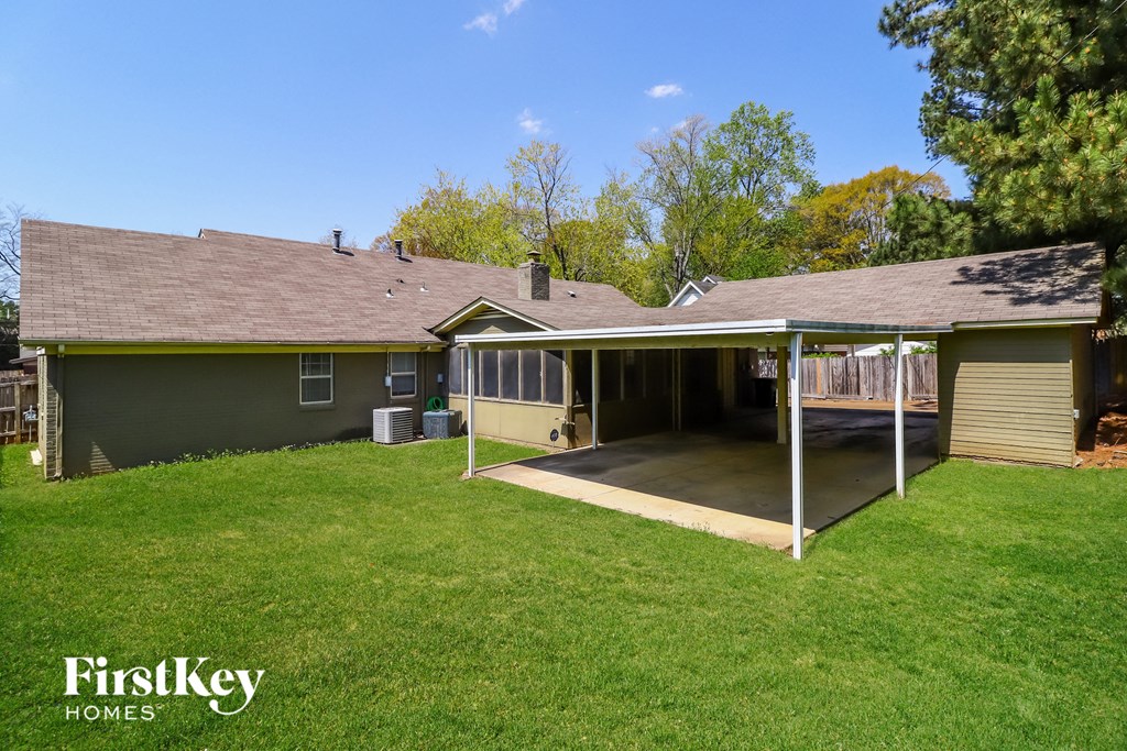 a covered patio in the back of a house