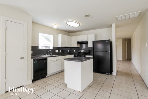 a kitchen with white cabinets and black appliances and a black refrigerator