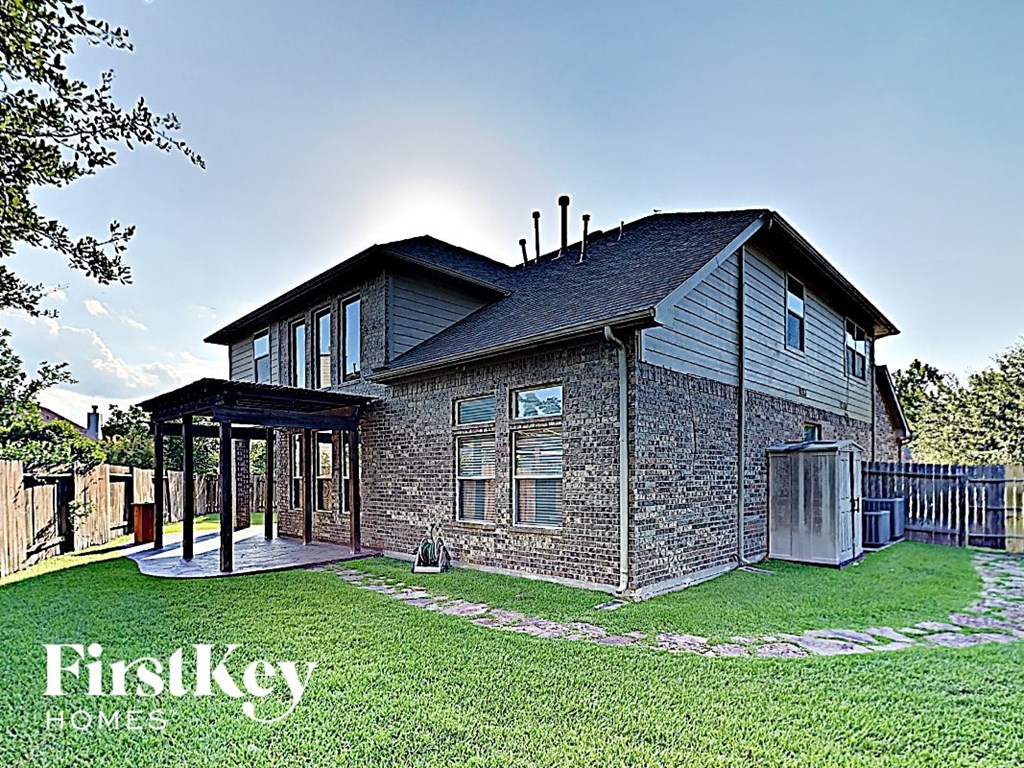 A house with a stone wall and a covered patio.