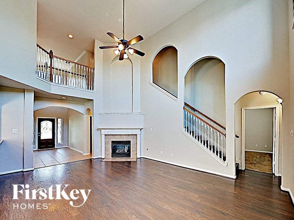A large open living room with a fireplace and a staircase.