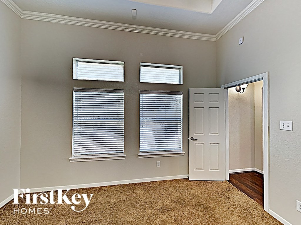 A room with two windows and a door leading to another room.