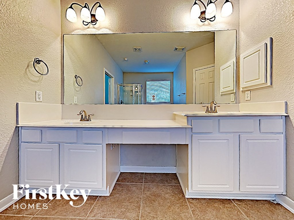 A bathroom with a double sink vanity and a large mirror.