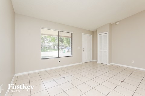 A spacious room with a large window and sliding glass doors.