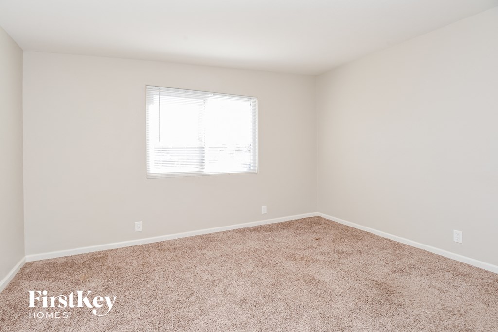 a bedroom with carpet and a window