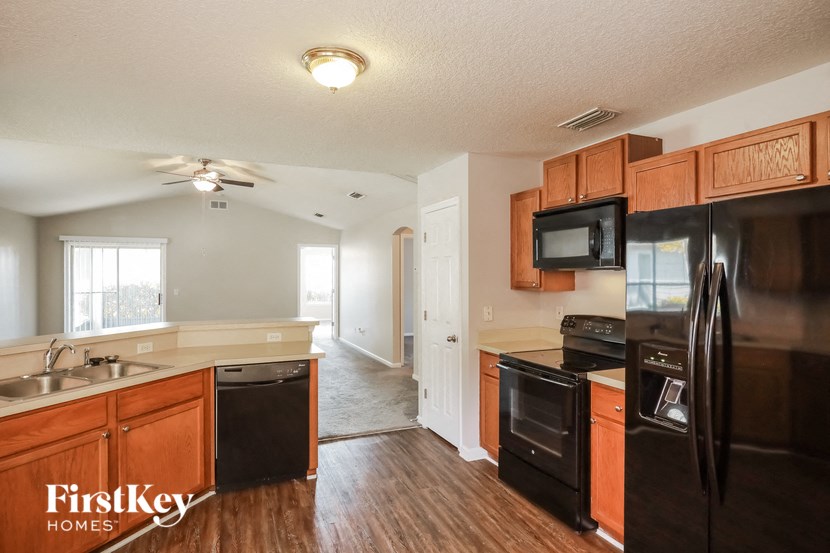 A kitchen with wooden cabinets and black appliances.