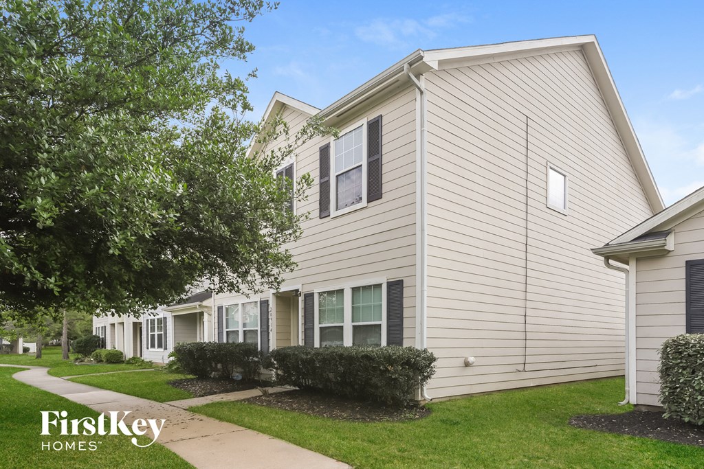 a white house with a sidewalk in front of it